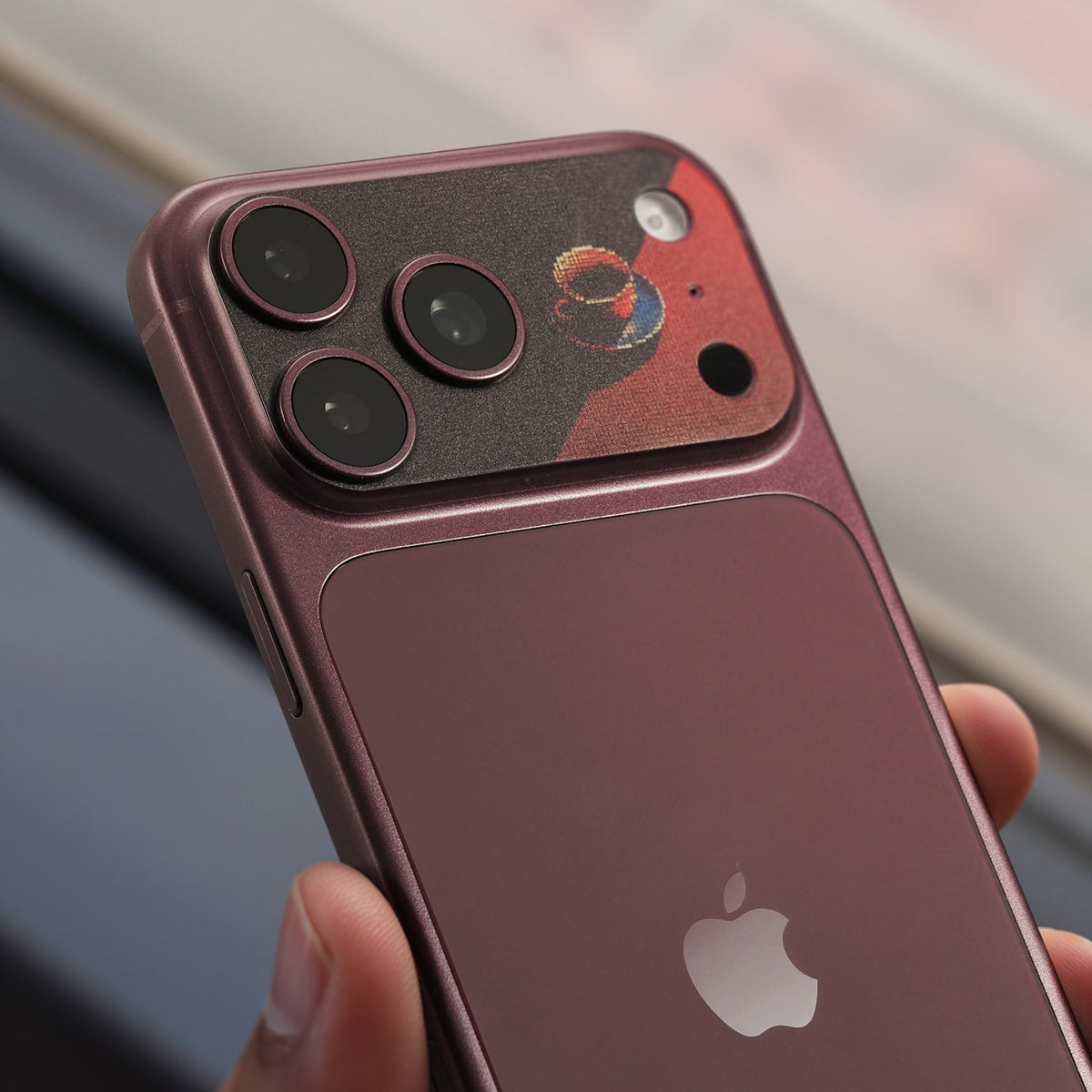 STICKSOO Camera Skin real photo on Burgundy iPhone 18 Pro Max, lifestyle view 5; alternate phone-colour reference photo